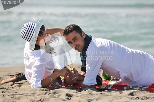 Image of young couple enjoying  picnic on the beach