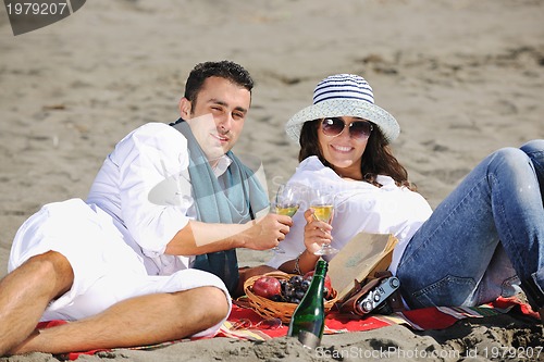 Image of young couple enjoying  picnic on the beach