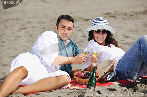 Image of young couple enjoying  picnic on the beach