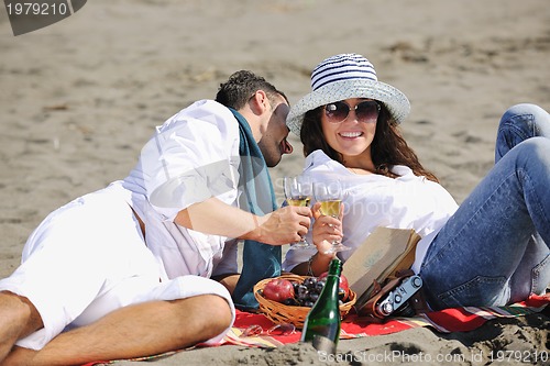 Image of young couple enjoying  picnic on the beach