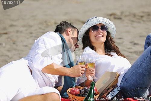 Image of young couple enjoying  picnic on the beach