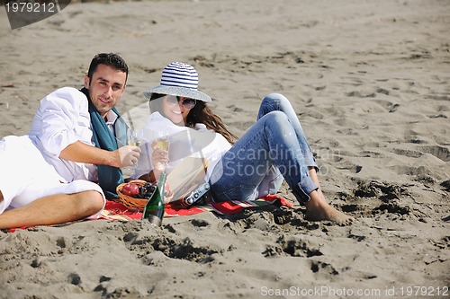 Image of young couple enjoying  picnic on the beach