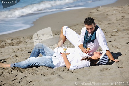 Image of young couple enjoying  picnic on the beach