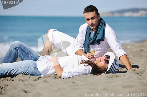 Image of young couple enjoying  picnic on the beach