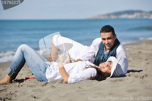 Image of young couple enjoying  picnic on the beach