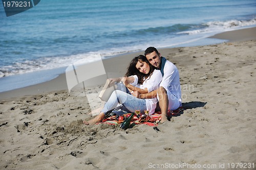 Image of young couple enjoying  picnic on the beach