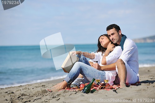 Image of young couple enjoying  picnic on the beach