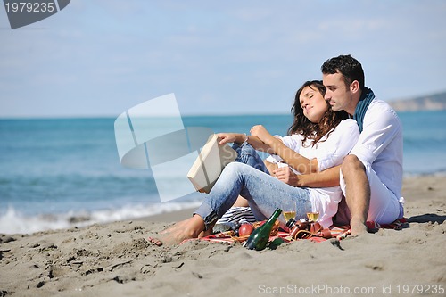 Image of young couple enjoying  picnic on the beach