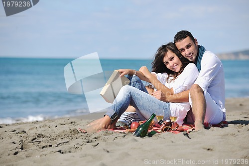 Image of young couple enjoying  picnic on the beach