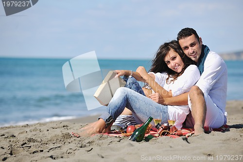 Image of young couple enjoying  picnic on the beach