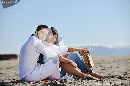 Image of young couple enjoying  picnic on the beach