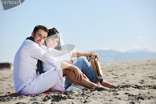 Image of young couple enjoying  picnic on the beach