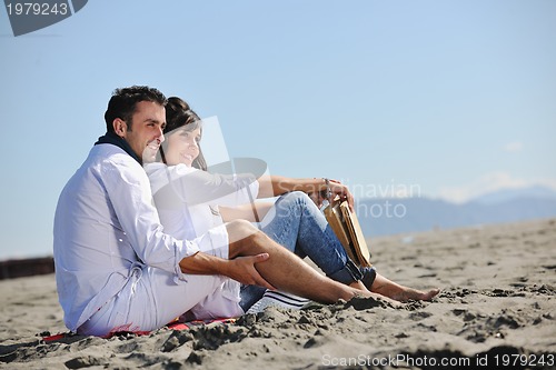 Image of young couple enjoying  picnic on the beach