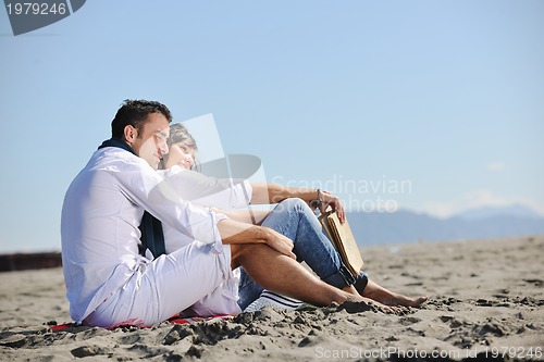 Image of young couple enjoying  picnic on the beach