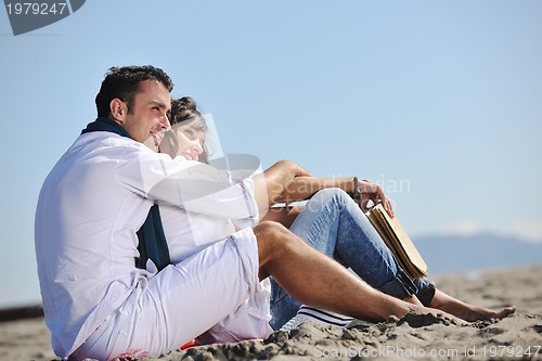 Image of young couple enjoying  picnic on the beach