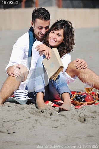 Image of young couple enjoying  picnic on the beach