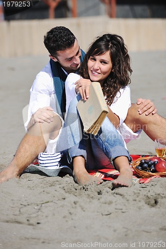 Image of young couple enjoying  picnic on the beach