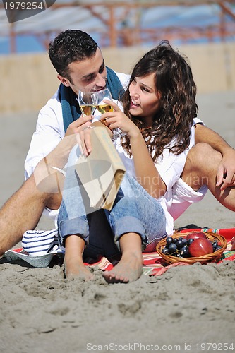 Image of young couple enjoying  picnic on the beach