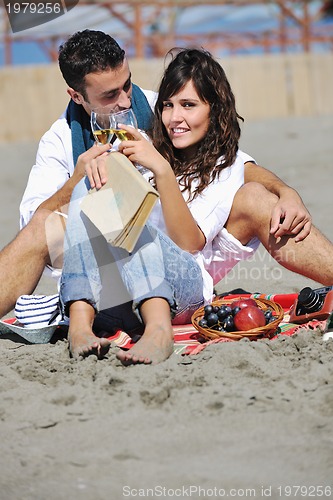 Image of young couple enjoying  picnic on the beach