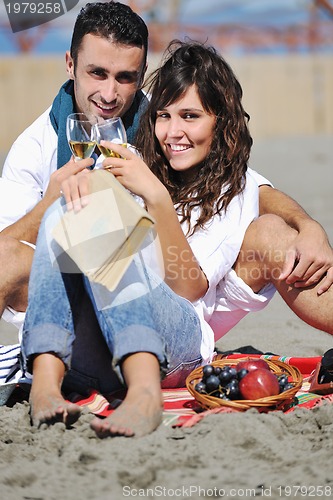 Image of young couple enjoying  picnic on the beach