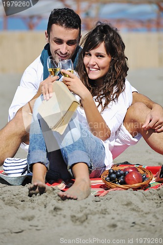 Image of young couple enjoying  picnic on the beach