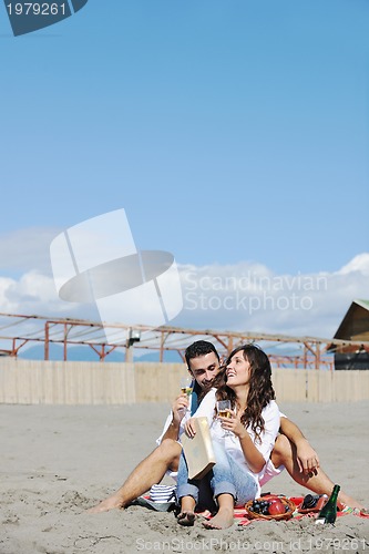 Image of young couple enjoying  picnic on the beach