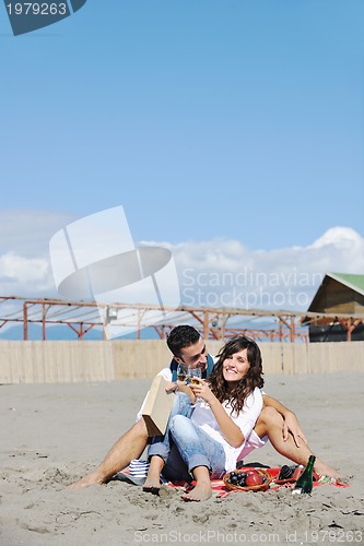 Image of young couple enjoying  picnic on the beach