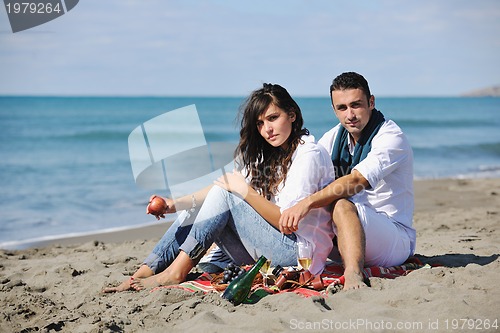 Image of young couple enjoying  picnic on the beach