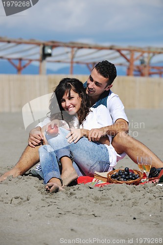 Image of young couple enjoying  picnic on the beach