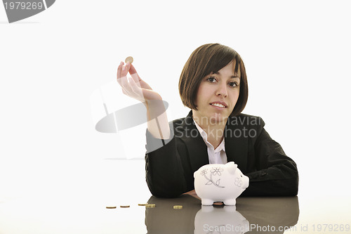 Image of business woman putting coins money in piggy bank