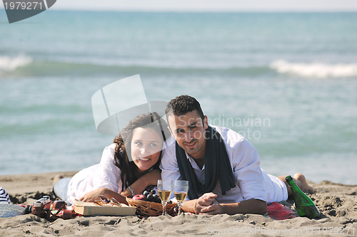Image of young couple enjoying  picnic on the beach