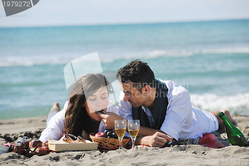 Image of young couple enjoying  picnic on the beach