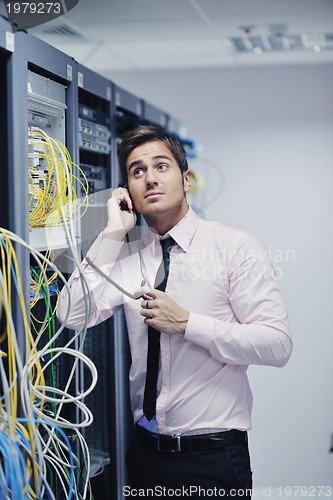 Image of it engeneer talking by phone at network room