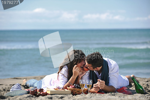 Image of young couple enjoying  picnic on the beach