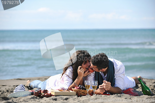 Image of young couple enjoying  picnic on the beach