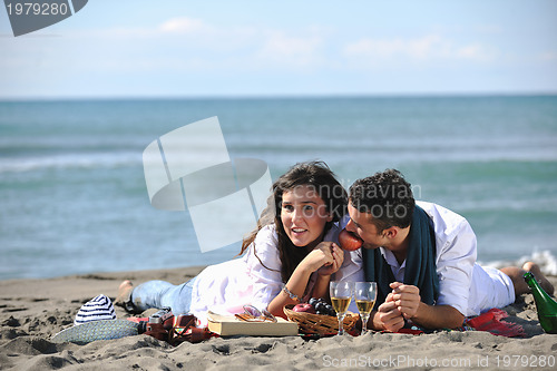 Image of young couple enjoying  picnic on the beach