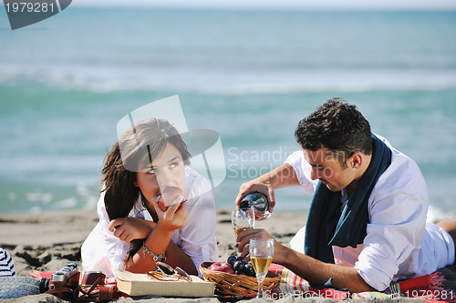 Image of young couple enjoying  picnic on the beach