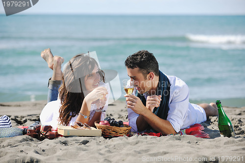 Image of young couple enjoying  picnic on the beach