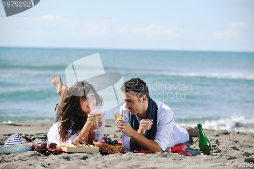 Image of young couple enjoying  picnic on the beach