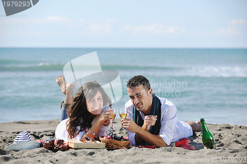 Image of young couple enjoying  picnic on the beach
