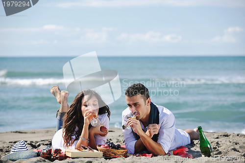 Image of young couple enjoying  picnic on the beach