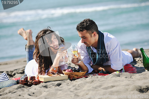 Image of young couple enjoying  picnic on the beach