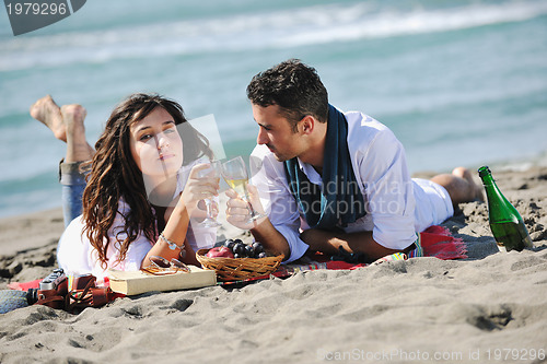 Image of young couple enjoying  picnic on the beach