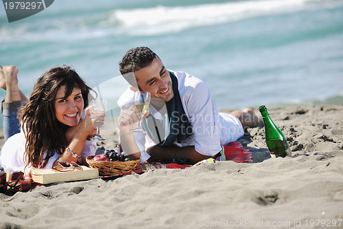 Image of young couple enjoying  picnic on the beach