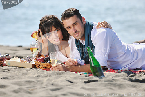 Image of young couple enjoying  picnic on the beach