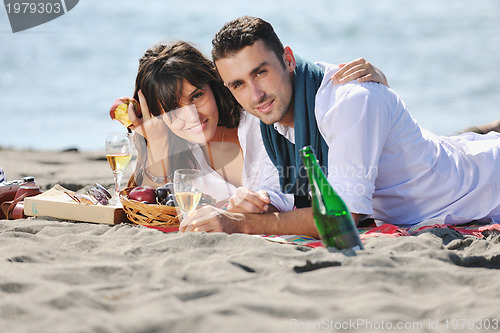 Image of young couple enjoying  picnic on the beach