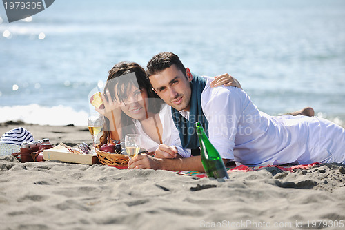 Image of young couple enjoying  picnic on the beach