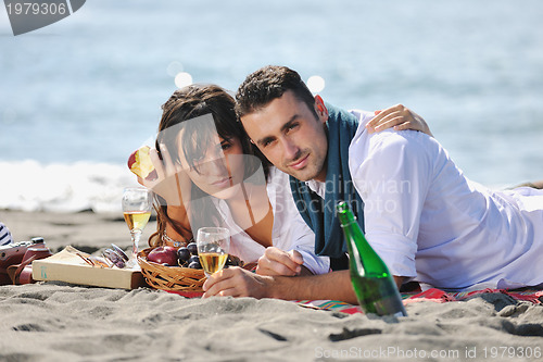 Image of young couple enjoying  picnic on the beach