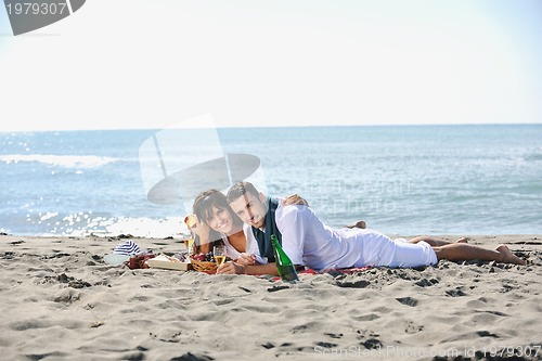 Image of young couple enjoying  picnic on the beach