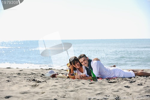 Image of young couple enjoying  picnic on the beach